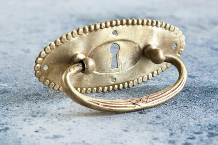 Antique brass drawer pull knob on concrete background. Copy space for text.の写真素材