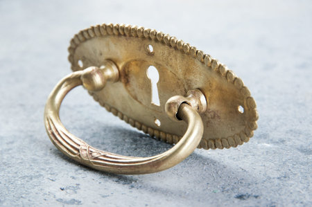 Antique brass drawer pull knob on concrete background. Copy space for text.