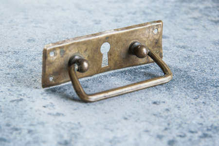 Antique brass drawer pull knob on concrete background. Copy space for text.の写真素材