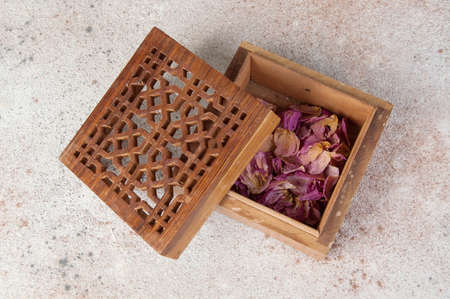 Vintage wooden aroma box with dried rose flowers on concrete background. Copy space for text.の写真素材