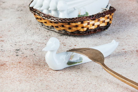 Antique porcelain duck cutlery stand on concrete background. Copy space for text, food photography props.の写真素材