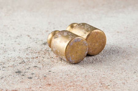 Two antique bronze weights for scales on concrete background. Copy space for text and food photography props.の写真素材