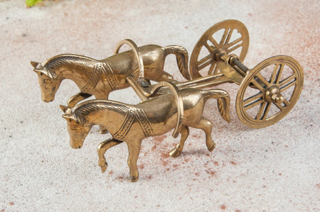 Antique bronze horses and cart sculpture on concrete background. Copy space for text.の写真素材
