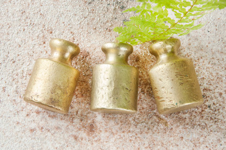Three antique bronze weights for scales on concrete background. Copy space for text and food...