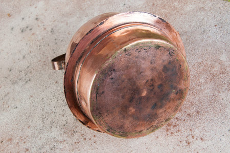 Old copper kettle on concrete background. Copy space for text, food photography props.