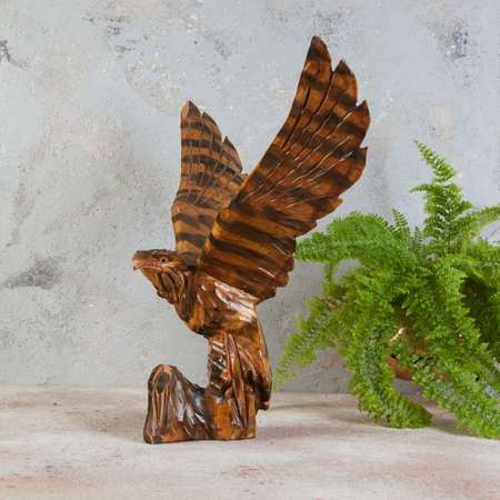 Large vintage wooden eagle figurine on concrete background. Copy space for text.の写真素材