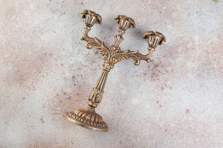 Antique brass candlestick for three candles on concrete background. Copy space for text.の写真素材