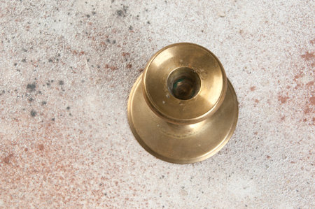Antique brass candlestick for one candle on concrete background. Copy space for text.