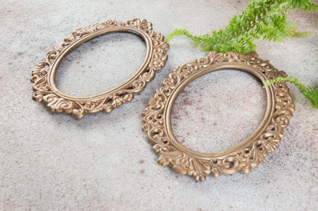 Two antique brass empty picture frames on concrete background. Photography props and copy space for...