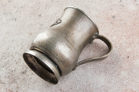 Antique metal cup on a concrete background. Copy space for text.