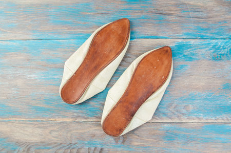 traditional moroccan shoes on blue wooden background. Copy space for text, photography props.の写真素材