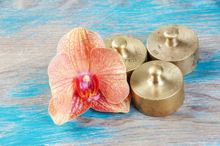 Three antique bronze weights for scales on blue wooden background. Copy space for text and food photography props.の写真素材