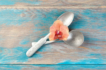 Two old aluminum spoons on blue wooden background. Copy space for text, food photography props.の写真素材