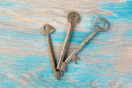 Old iron keys, detail of a classic metal keys on wooden background. Copy space for text`の写真素材