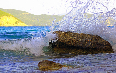 Waves splash into the rocksの写真素材