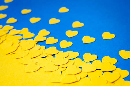 Papercut concept with yellow paper hearts forming an ukrainian flag motive on the blue background.の写真素材