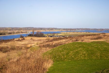Water channel into the sea among green meadow. Winter in Denmarkの写真素材