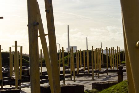 Green small hills in the park. In the background a factory with a large chimney. Denmark.の写真素材