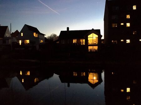 the river aire in leeds at night with illuminated windows in apartment buildings and offices reflected in the water. Odense. Denmark.の写真素材