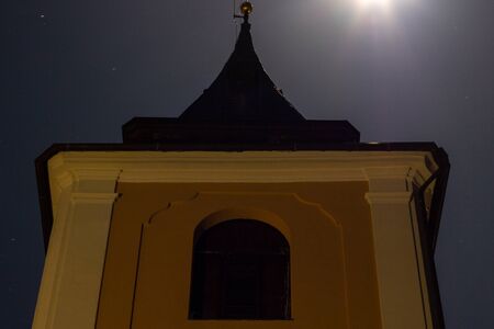 Detail of night illuminated historic Catholic church in moonlight.の写真素材