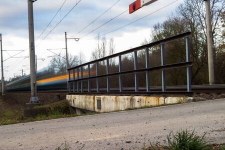 Fast train passing under a bridge on a lovely summer day motion blurred image.の写真素材