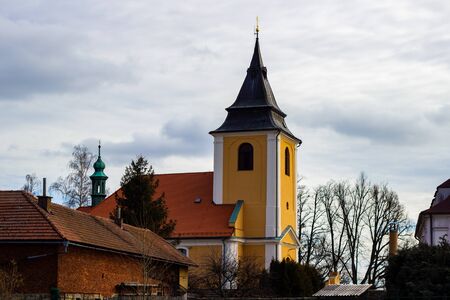 Beautiful medieval Czech church tower behind leafless trees. Czech Republic.の写真素材