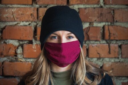 Girl with mask to protect her from Corona virus. Corona virus pandemic. Beautiful girl with red mask. Coronavirusの写真素材