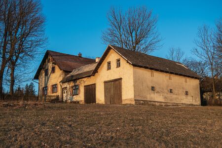 old house and old tree lit by the sun at sunset, the picture itself says stay home. Czech Republicの写真素材