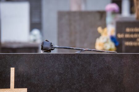 Black roses on black granite tombstone outdoors. Funeral ceremonyの写真素材