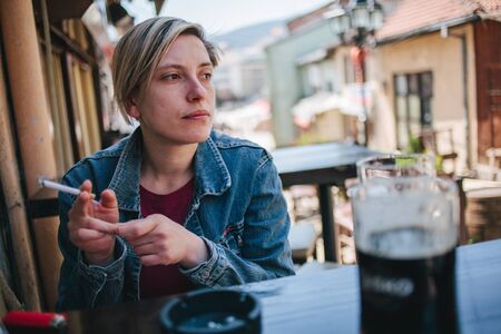 Woman smoking cigarette outdoorの写真素材