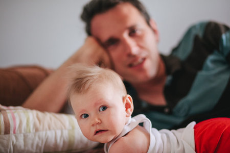 Father and baby laying on the bedの写真素材