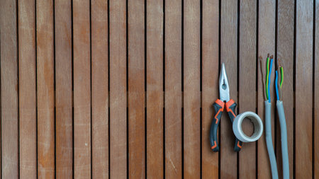Tool set - wire cutters, wire, insulating tape on a wooden background