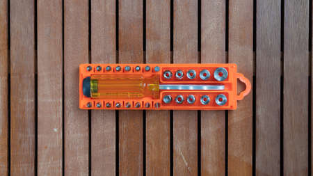 Screwdriver with a set of bits in a plastic case on a wooden backgroundの写真素材