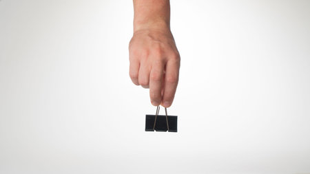 A mans hand on top holds a clip to clip paper space for text