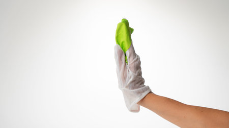 Hand in a clean glove with a green cloth for wiping screens side view requires the monitor
