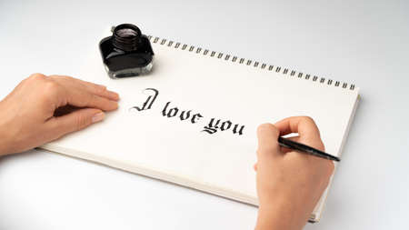 Womens hands write I love you fountain pen for calligraphyの写真素材