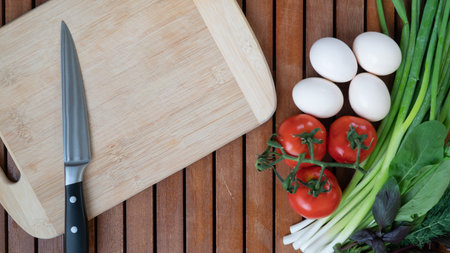 Vegetables greens, eggs on the table with a board and a knife for cooking