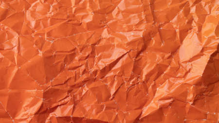 Wrinkled colored paper background texture voluminous orangeの写真素材