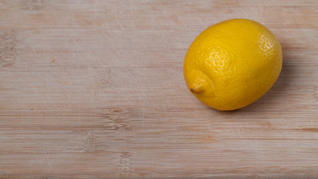 One lemon on a wooden background with space for textの写真素材