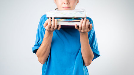 Womens chin on a stack of books and notebooks, studies