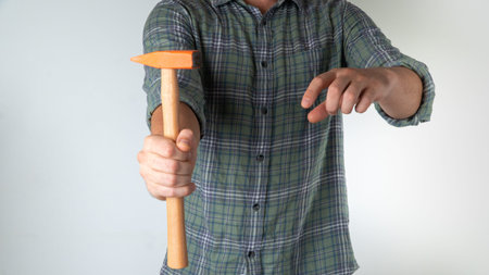 A man holds a hammer in his hand - home repairs
