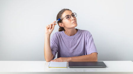 A girl student with a laptop and a notebook thought about itの写真素材