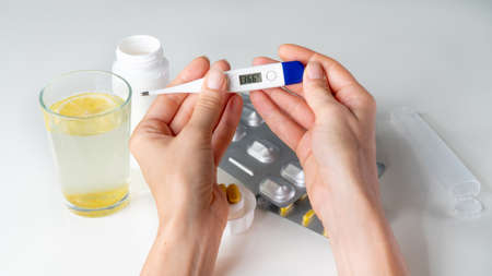 Temperature on the thermometer 36.6 - a recovered person against the background of tabletsの写真素材