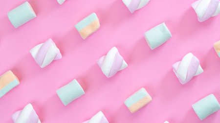 marshmallows on pink background diagonal lines close-up, multi-colored sweetsの写真素材