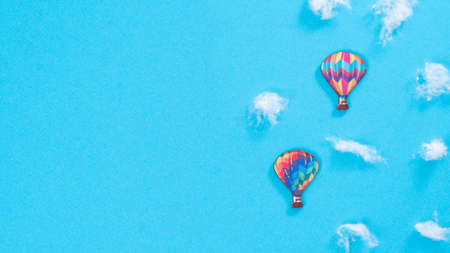 Balloons in the clouds of cotton wool on a blue background, a place for inscriptionの写真素材