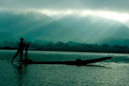 silhouette of fisherman in boatの写真素材