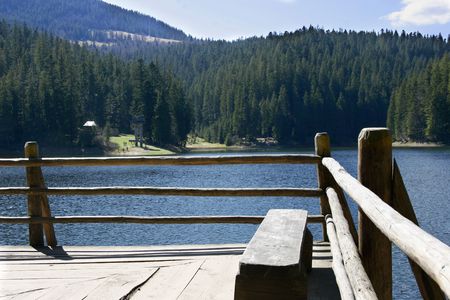 wooden bench on lake shoreの写真素材