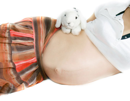 pregnant woman with toy rabbit over white