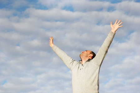 happy man with his hands up on sky background