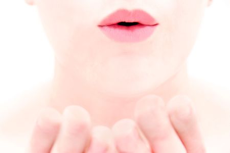 close up of female lips blowing a kiss over whiteの写真素材